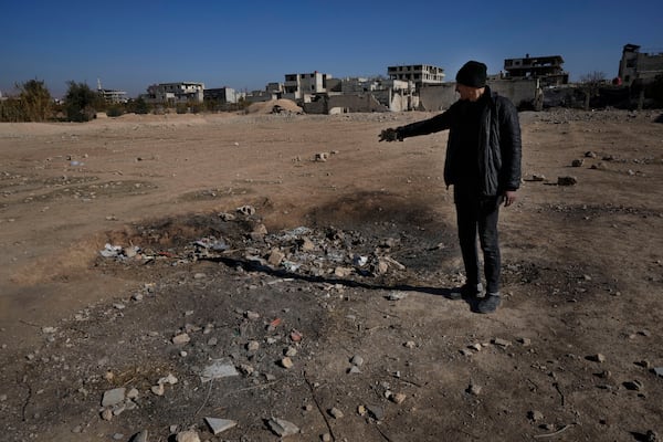 Hassan Arbeeni, 42, shows a crater where a surface-to-surface missile loaded with sarin struck, during a 2013 chemical weapons attack that was blamed on then President Bashar Assad's forces, in Zamalka neighbourhood, on the outskirts of Damascus, Syria, Wednesday, Dec. 25, 2024. (AP Photo/Hussein Malla)