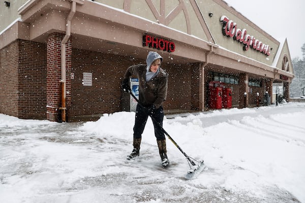 Jake Grant clears snow covered sidewalks at the Walgreens on Friday, Jan. 10, 2025 in Memphis, Tenn. (Mark Weber/Daily Memphian via AP)