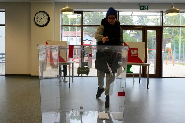 A voter casts a ballot shortly after polling stations opened in the first round of Poland's presidential elections in Łomianki, near Warsaw, on Sunday, May 18, 2025. (AP Photo/Czarek Sokolowski)