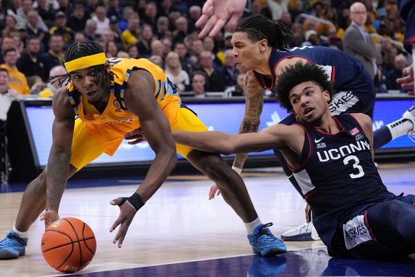 Marquette's Chase Ross and UConn's Jaylin Stewart go after a loose ball during the first half of an NCAA college basketball game Saturday, Feb. 1, 2025, in Milwaukee. (AP Photo/Morry Gash)