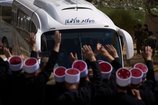 Buses carrying members of the Syrian Druze community are welcomed by Druze clerics at the border with Syria, as they enter into the village of Majdal Shams, in the Israeli-controlled Golan Heights, Friday, March 14, 2025. (AP Photo/Leo Correa)