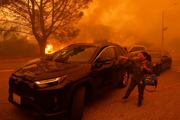 A woman cries as the Palisades Fire advances in the Pacific Palisades neighborhood of Los Angeles Tuesday, Jan. 7, 2025. (AP Photo/Etienne Laurent)