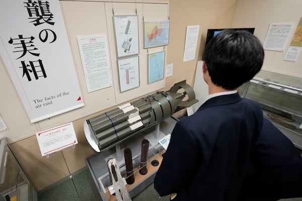 One of middle school students from Niigata on a school trip looks at model of an incendiary bomb is on display at the Center of the Tokyo Raids and War Damage, on Feb. 24, 2025, in Tokyo. (AP Photo/Eugene Hoshiko)