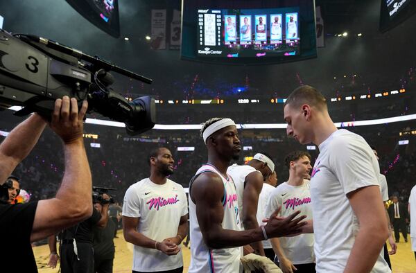 Miami Heat forward Jimmy Butler, second from left, shakes hands with forward Nikola Jovic, right, before an NBA basketball game against the Denver Nuggets, Friday, Jan. 17, 2025, in Miami. (AP Photo/Lynne Sladky)