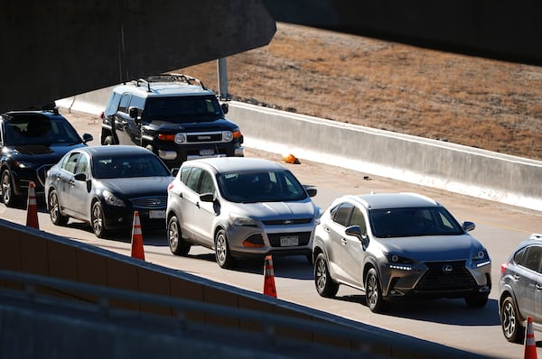 Motorists sit in a long line to pick up travelers arriving in the main terminal of Denver International Airport Tuesday, Dec. 24, 2024, in Denver. (AP Photo/David Zalubowski)