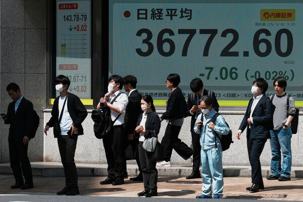 People stand in front of an electronic stock board showing Japan's Nikkei index at a securities firm Thursday, May 8, 2025, in Tokyo. (AP Photo/Eugene Hoshiko)