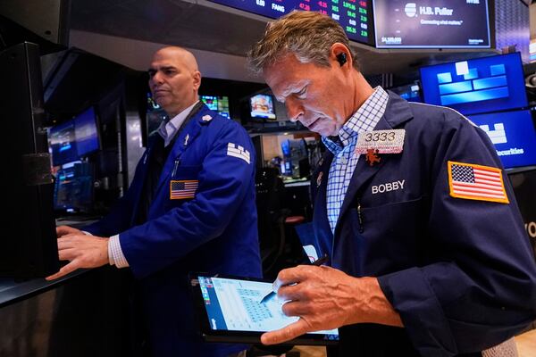 Specialist Philip Finale, left, and trader Robert Charmak work on the floor of the New York Stock Exchange, Friday, May 2, 2025. (AP Photo/Richard Drew)