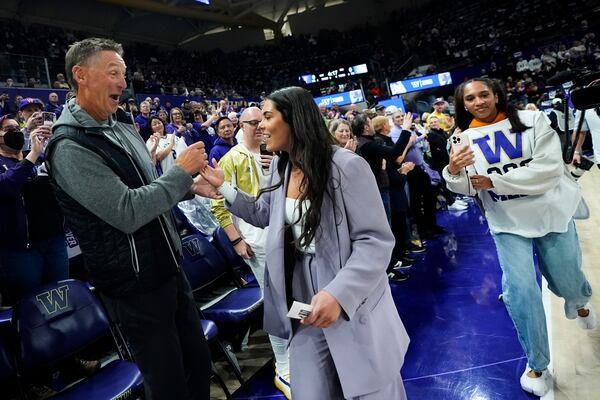 Former Washington player and current Las Vegas Aces guard Kelsey Plum, right, greets former NBA player Detlef Schrempf, left, before an NCAA college basketball game between Washington and Purdue prior to her jersey retirement ceremony at halftime, Saturday, Jan. 18, 2025, in Seattle. (AP Photo/Lindsey Wasson)