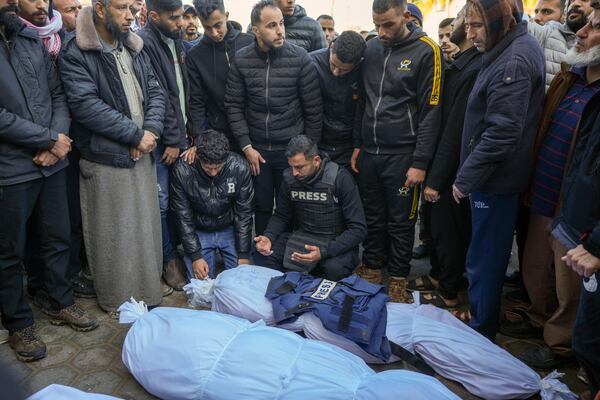 Colleagues and friends mourn over the body of freelance journalist Omar al-Derawi and other victims of overnight Israeli army strikes at multiple locations in central Gaza Strip, at Al-Aqsa Martyrs Hospital in Deir al-Balah, Friday, Jan. 3, 2025. According to Al-Aqsa Martyrs Hospital, 30 people, including 10 women and 7 children, were killed in several attacks overnight in central Gaza. (AP Photo/Abdel Kareem Hana)