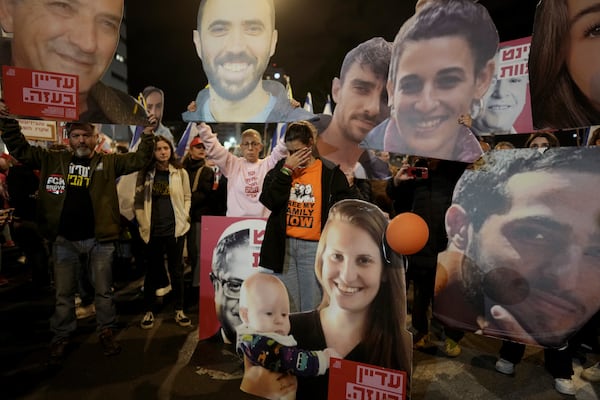 Demonstrators calling for the release of all hostages gather during a protest in Tel Aviv, Israel, as Israel's security cabinet convened to decide whether to approve a deal that would release dozens of hostages held by militants in Gaza and pause the 15-month-war Saturday, Jan. 18, 2025. (AP Photo/Oded Balilty)