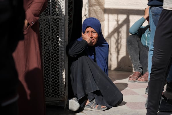 A woman reacts next to bodies of Palestinians who were killed in an Israeli army airstrikes are brought to the Al-Ahli Hospital in Gaza City, Tuesday, March 18, 2025. (AP Photo/Abdel Kareem Hana)