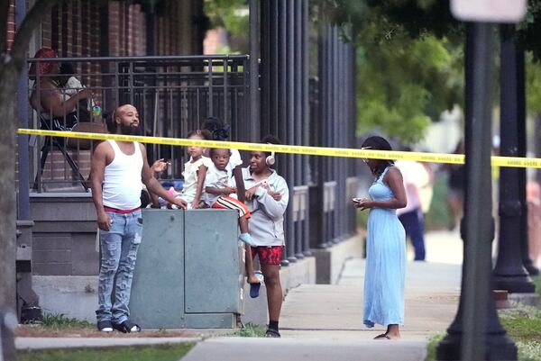 Residents watch as police pursue a fugitive that escaped from a New Orleans jail, Tuesday, May 20, 2025, in New Orleans. (AP Photo/Gerald Herbert)