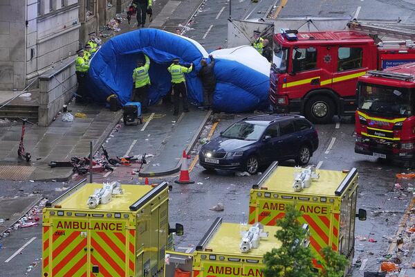 Police and emergency personnel deal with an incident after a car collided with pedestrians near the Liver Building during the Premier League winners parade in Liverpool, England, Monday, May 26, 2025.(AP Photo/Jon Super)