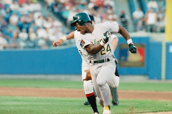 FILE - Oakland Athletics Rickey Henderson (24) keeps just ahead of Chicago White Sox shortstop Ozzie Guillen during a rundown between first and second base during the third inning of a baseball game June 14, 1994, in Chicago. (AP Photo/Fred Jewell, File)