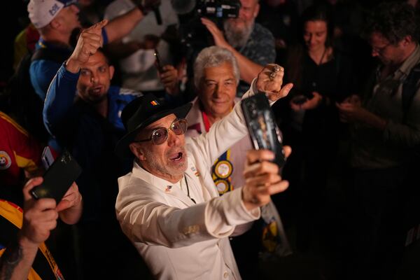 Supporters of Presidential candidate George Simion react to the exit poll results during the first round of the country's presidential election redo in Bucharest, Romania, Sunday, May 4, 2025. (AP Photo/Andreea Alexandru)