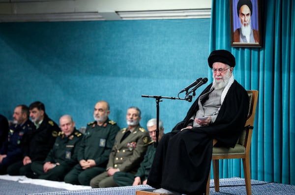 In this photo released by the official website of the office of the Iranian supreme leader, Supreme Leader Ayatollah Ali Khamenei speaks under a portrait of the late revolutionary founder Ayatollah Khomeini, as armed forces commander listen, at rear, in a ceremony meeting a group of officials, in Tehran, Iran, Saturday, March 8, 2025. (Office of the Iranian Supreme Leader via AP)