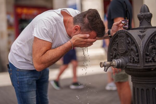 FILE - A man cool off in a fountain during a hot and sunny day of summer in Madrid, Spain, July 19, 2023. (AP Photo/Manu Fernandez, File)