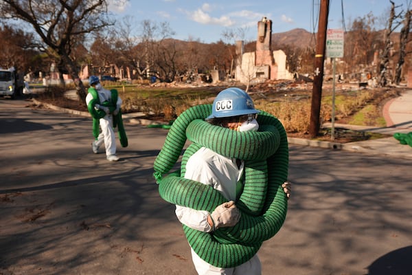 A member of the California Conservation Corps works in the rubble of the Palisades Fire in the Pacific Palisades section of Los Angeles, Monday, Jan. 27, 2025. (AP Photo/Jae C. Hong)