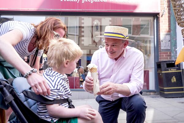 Liberal Democrat Leader Sir Ed Davey serves up ice cream in the hot weather in Shrewsbury, Shropshire, England, to thank voters following the local elections, on Friday May 2, 2025. (James Street/PA via AP)