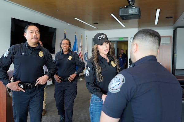 Homeland Security Secretary Kristi Noem, second right, greets officers with Sidney Aki, director of field operations for the Customs and Border Protection (CBP) San Diego field office, left, as she tours the San Ysidro Port of Entry, Sunday, March 16, 2025, in San Diego. (AP Photo/Alex Brandon)