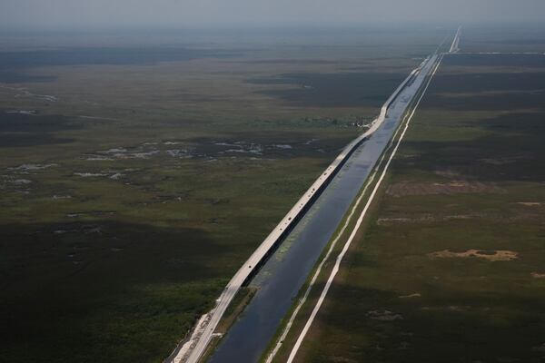 Sections of the Tamiami Trail which have been replaced with bridges to allow water to flow freely into Everglades National Park, at left, are seen from the air during a flight donated by LightHawk over the Everglades in southern Florida, Friday, May 17, 2024. (AP Photo/Rebecca Blackwell)