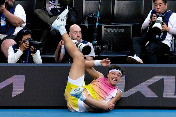 Ben Shelton of the U.S. falls into signboards after a fall during his quarterfinal match against Lorenzo Sonego of Italy at the Australian Open tennis championship in Melbourne, Australia, Wednesday, Jan. 22, 2025. (AP Photo/Ng Han Guan)