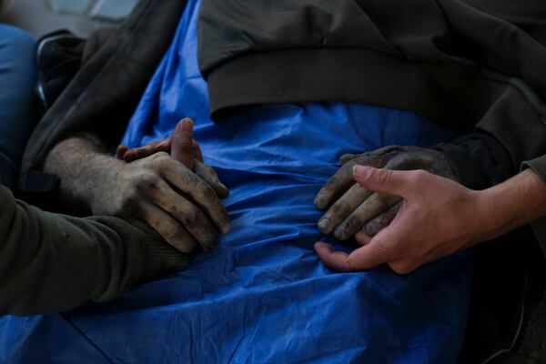 EDS NOTE: GRAPHIC CONTENT - EDS NOTE GRAPHIC CONTENT.- Palestinians hold the hands of their relative who was killed in an Israeli army airstrike, at Shifa Hospital in Gaza City, Tuesday, March 18, 2025. (AP Photo/Abdel Karem Hanna)