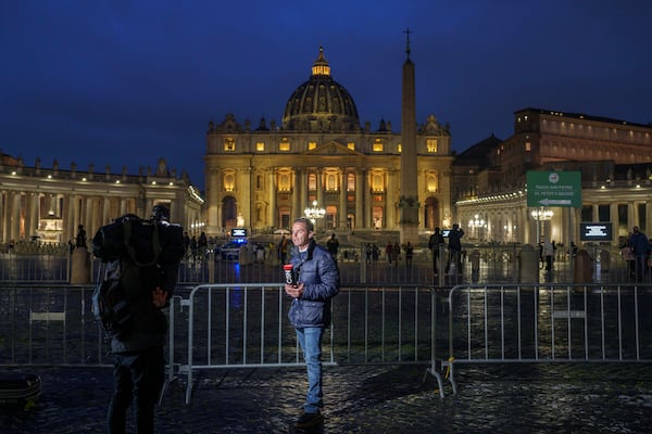 A journalist works next to St. Peter's Square at The Vatican, Monday, Feb. 24, 2025. (AP Photo/Bernat Armangue)