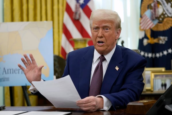 President Donald Trump speaks to reporters in the Oval Office of the White House, where he signed an executive order, Thursday, Feb. 13, 2025, in Washington. (AP Photo/Ben Curtis)