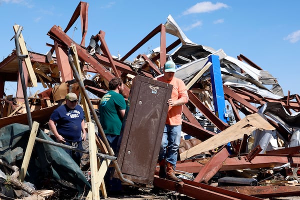 Friends and family members search for belongings in the damage after a tornado passed through the area, Sunday, March 16, 2025, in Plantersville, Ala. (AP Photo/Butch Dill)