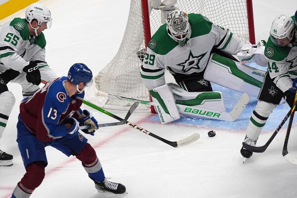 Colorado Avalanche right wing Valeri Nichushkin (13) shoots the puck past Dallas Stars defenseman Thomas Harley (55) as Stars goaltender Jake Oettinger (29) covers the net in the first period of Game 6 of an NHL hockey first-round playoff series Thursday, May 1, 2025, in Denver. (AP Photo/David Zalubowski)