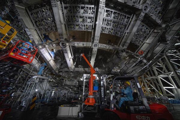 Workers labor on the underside of the cosmic detector located 2297 feet (700 meters) underground at the Jiangmen Underground Neutrino Observatory in Kaiping, southern China's Guangdong province on Friday, Oct. 11, 2024. (AP Photo/Ng Han Guan)