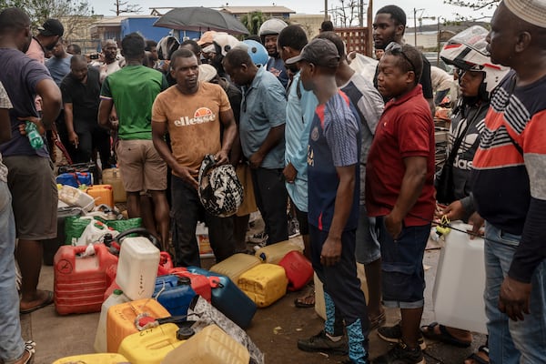 People queue for gas in Mamoudzou, in the French Indian Ocean island of Mayotte, Thursday, Dec. 19, 2024, after Cyclone Chido. (AP Photo/Adrienne Surprenant)