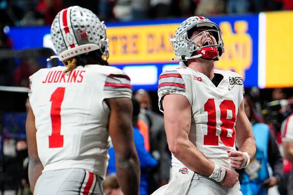 Ohio State quarterback Will Howard celebrates after a touchdown by running back Quinshon Judkins during second half of the College Football Playoff national championship game against Notre Dame Monday, Jan. 20, 2025, in Atlanta. (AP Photo/Jacob Kupferman)