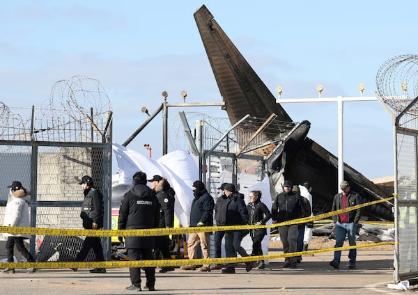 Experts from the U.S. National Transportation Safety Board (NTSB) and representatives from aircraft manufacturer Boeing Co. investigate the site of a plane crash at Muan International Airport in Muan, South Korea, Tuesday, Dec. 31, 2024. (Kim Sung-min/Yonhap via AP)