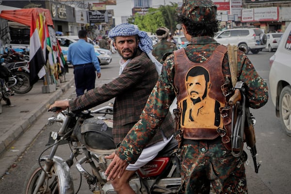 A Houthi military wears a vest showing a drawing of the leader of the Houthi movement Abdul Malik al-Houthi as he directs traffic during an anti-U.S. and anti-Israel rally in Sanaa, Yemen, Monday, March 17, 2025. (AP Photo/Osamah Abdulrahman)