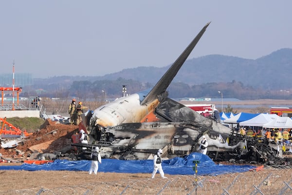 Firefighters and rescue team members work near the wreckage of a passenger plane at Muan International Airport in Muan, South Korea, Sunday, Dec. 29, 2024. (AP Photo/Ahn Young-joon)