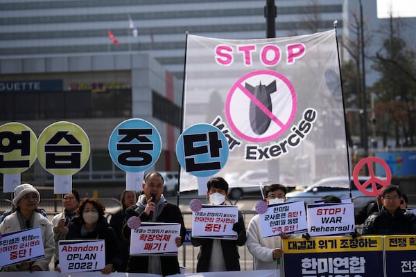 Protesters gather during a press conference demanding to stop the upcoming Freedom Shield military exercise between the U.S. and South Korea, near the Defense Ministry in Seoul, South Korea, Monday, March 10, 2025. The letters read "Stop, War exercise." (AP Photo/Lee Jin-man)