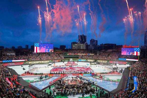 Fireworks explode during the Star-Spangled Banner before the NHL Winter Classic outdoor hockey game featuring the Chicago Blackhawks and St. Louis Blues at Wrigley Field, Tuesday, Dec. 31, 2024, in Chicago. (AP Photo/Erin Hooley)