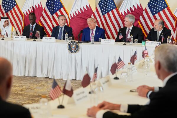 President Donald Trump speaks, seated between Kelly Ortberg President and CEO of Boeing, left, and Larry Culp, CEO of GE Aerospace during a business roundtable, Thursday, May 15, 2025, in Doha, Qatar. (AP Photo/Alex Brandon)