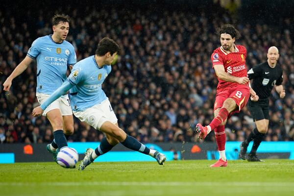 Liverpool's Dominik Szoboszlai, right, scores his side's 2nd goal during the English Premier League soccer match between Manchester City and Liverpool at Etihad stadium in Manchester, England, Sunday, Feb. 23, 2025. (AP Photo/Dave Thompson)