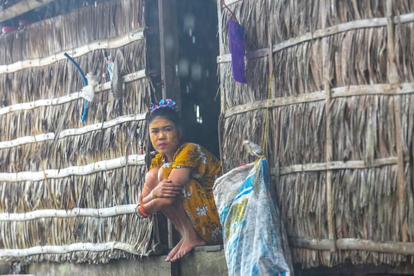 Tepan Klathale sits on her house in Moken village at Surin Islands in Phang Nga Province, Thailand, on a rainy Thursday, Dec. 12, 2024. (AP Photo/Sakchai Lalit)