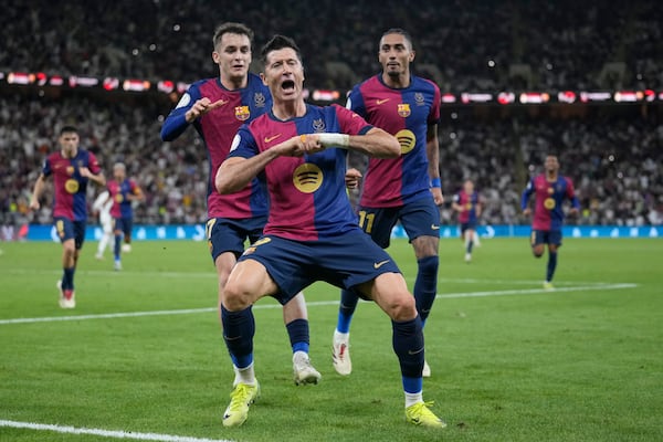 Barcelona's Robert Lewandowski, centre, celebrates after scoring his side's second goal during the Spain Super Cup final soccer match between Real Madrid and Barcelona at King Abdullah Stadium in Jeddah, Saudi Arabia, Sunday, Jan. 12, 2025. (AP Photo/Altaf Qadri)