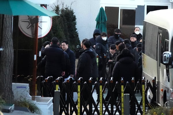 Investigators from the Corruption Investigation Office for High-ranking Officials arrive at the gate of the presidential residence as supporters of impeached South Korean President Yoon Suk Yeol stage a rally to oppose a court having issued a warrant to detain Yoon, in Seoul, South Korea, Friday, Jan. 3, 2025. (AP Photo/Lee Jin-man)