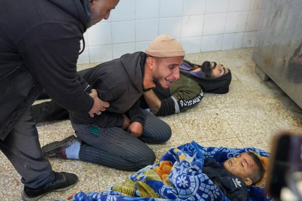 The uncle of 8-year-old Adam Farajallah grieves over his body after it was brought to Al-Aqsa Martyrs Hospital following an airstrike on a house in the Bureij refugee camp, in the central Gaza Strip town of Deir al-Balah Wednesday, Jan. 1, 2025. (AP Photo/Abdel Kareem Hana)