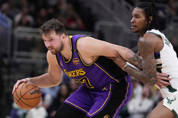 Los Angeles Lakers' Luka Doncic tries to get by Milwaukee Bucks' Kevin Porter Jr. during the first half of an NBA basketball game Thursday, Mar. 13, 2025, in Milwaukee. (AP Photo/Morry Gash)