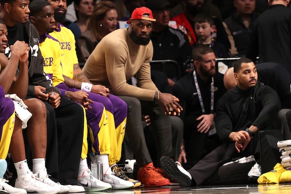 Los Angeles Lakers' LeBron James, center, sits on the bench during the second half of an NBA basketball game against the Brooklyn Nets, Monday, March 10, 2025, in New York. (AP Photo/Pamela Smith)