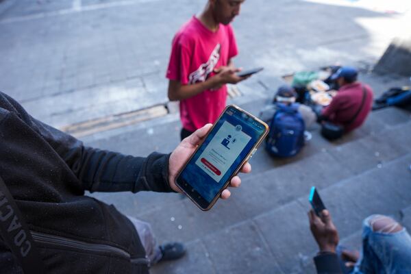 FILE - Venezuelan migrant Yender Romero shows the U.S. Customs and Border Protection (CBP) One app on his cell phone at a migrant tent camp outside La Soledad church in Mexico City on Jan. 20, 2025. (AP Photo/Fernando Llano, File)