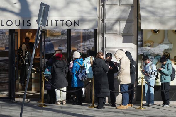 People stand in line at an accessories store in the center of Helsinki, Finland, Saturday, March 15, 2025. (AP Photo/Sergei Grits)