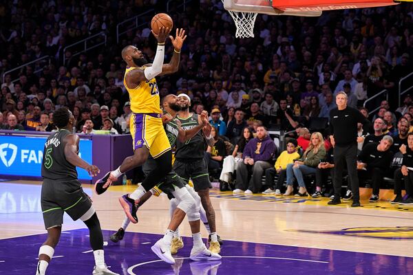 Los Angeles Lakers forward LeBron James (23) shoots as Minnesota Timberwolves guard Anthony Edwards (5), center Rudy Gobert (27) and guard Nickeil Alexander-Walker (9) defend during the second half in Game 5 of an NBA basketball first-round playoff series Wednesday, April 30, 2025, in Los Angeles. (AP Photo/Mark J. Terrill)